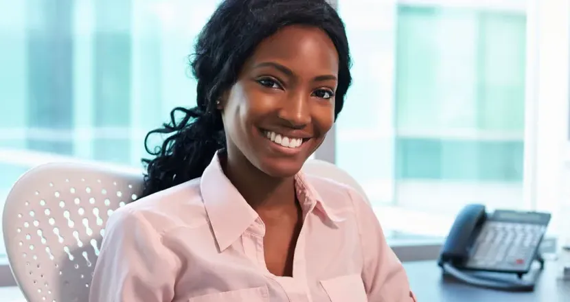 Medical Office Administrator Smiling at Desk