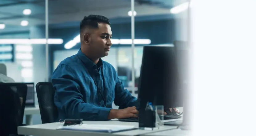 Software Developer Seated at Computer Desk In Office